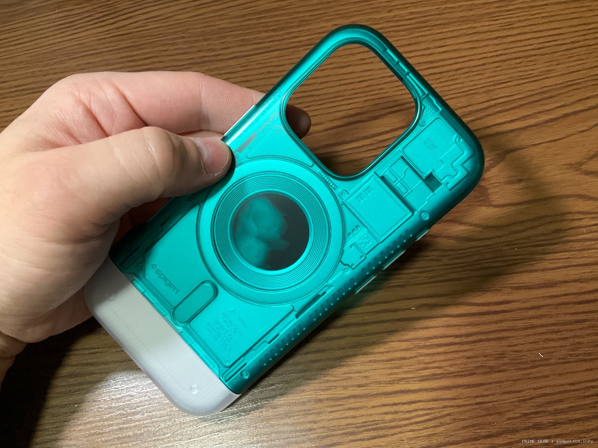 緑色のスマホケースを持つ手