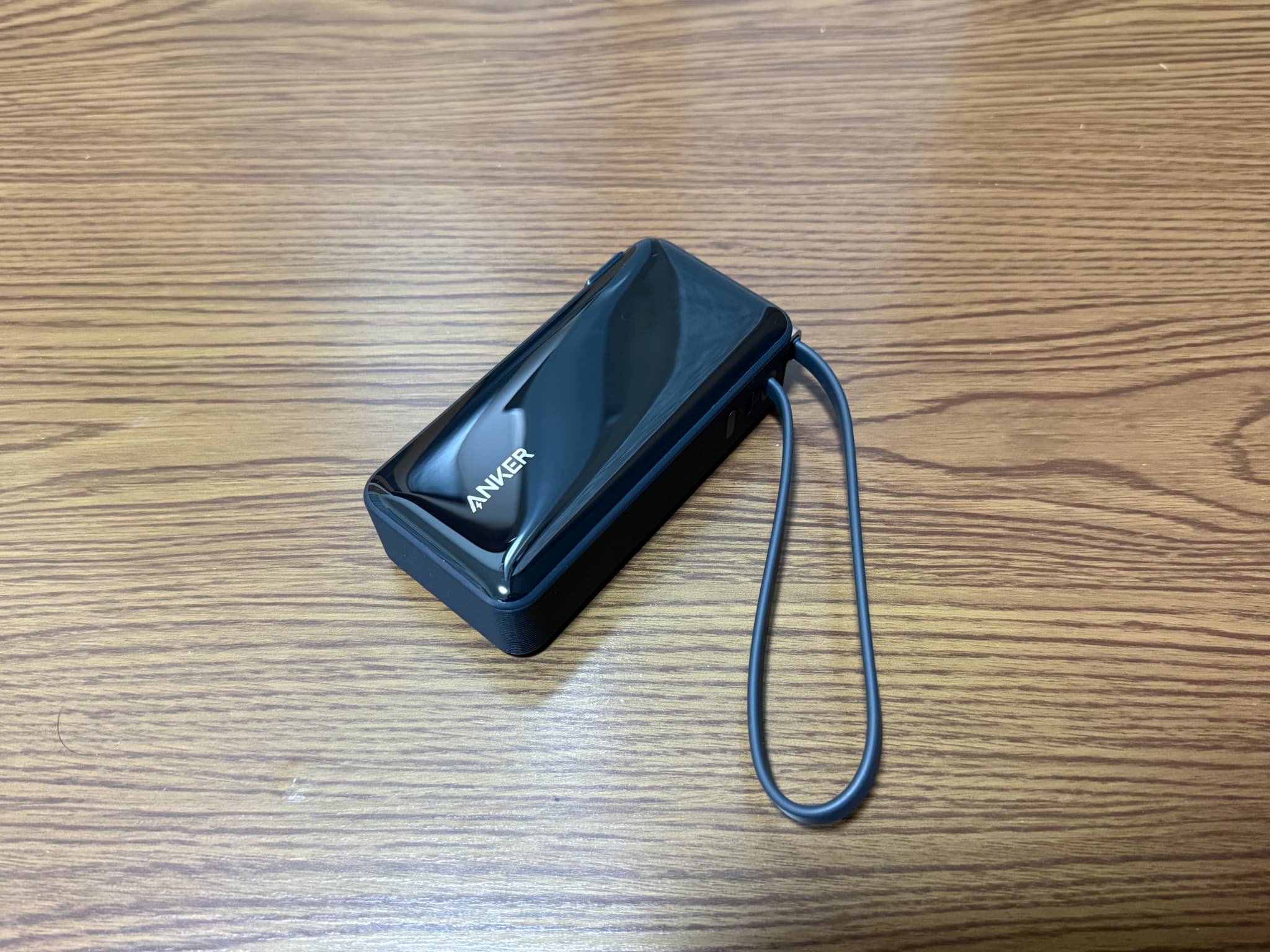 木目調のテーブルに置かれた黒色の充電バッテリー