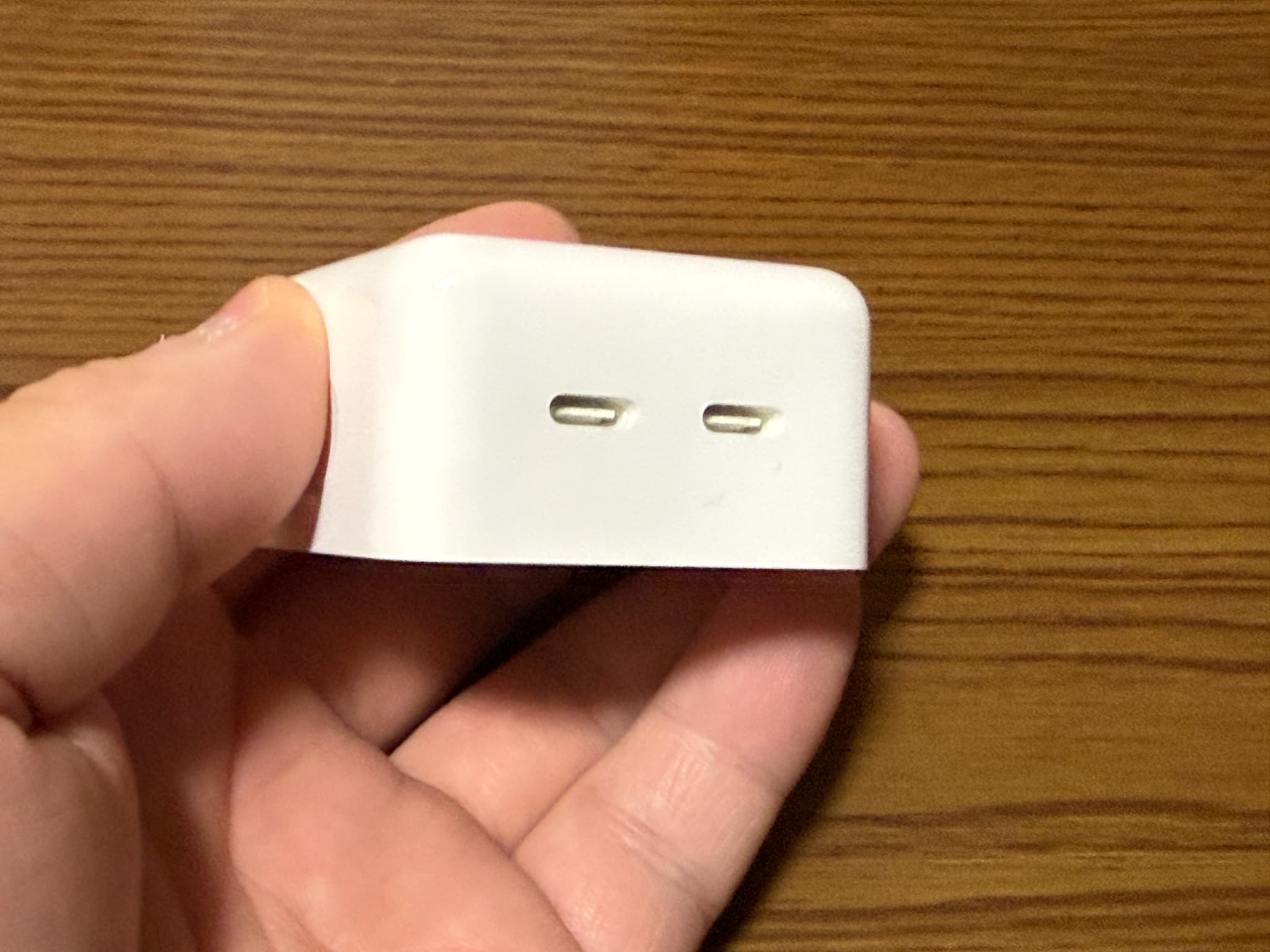 指で持っている白いUSB充電器