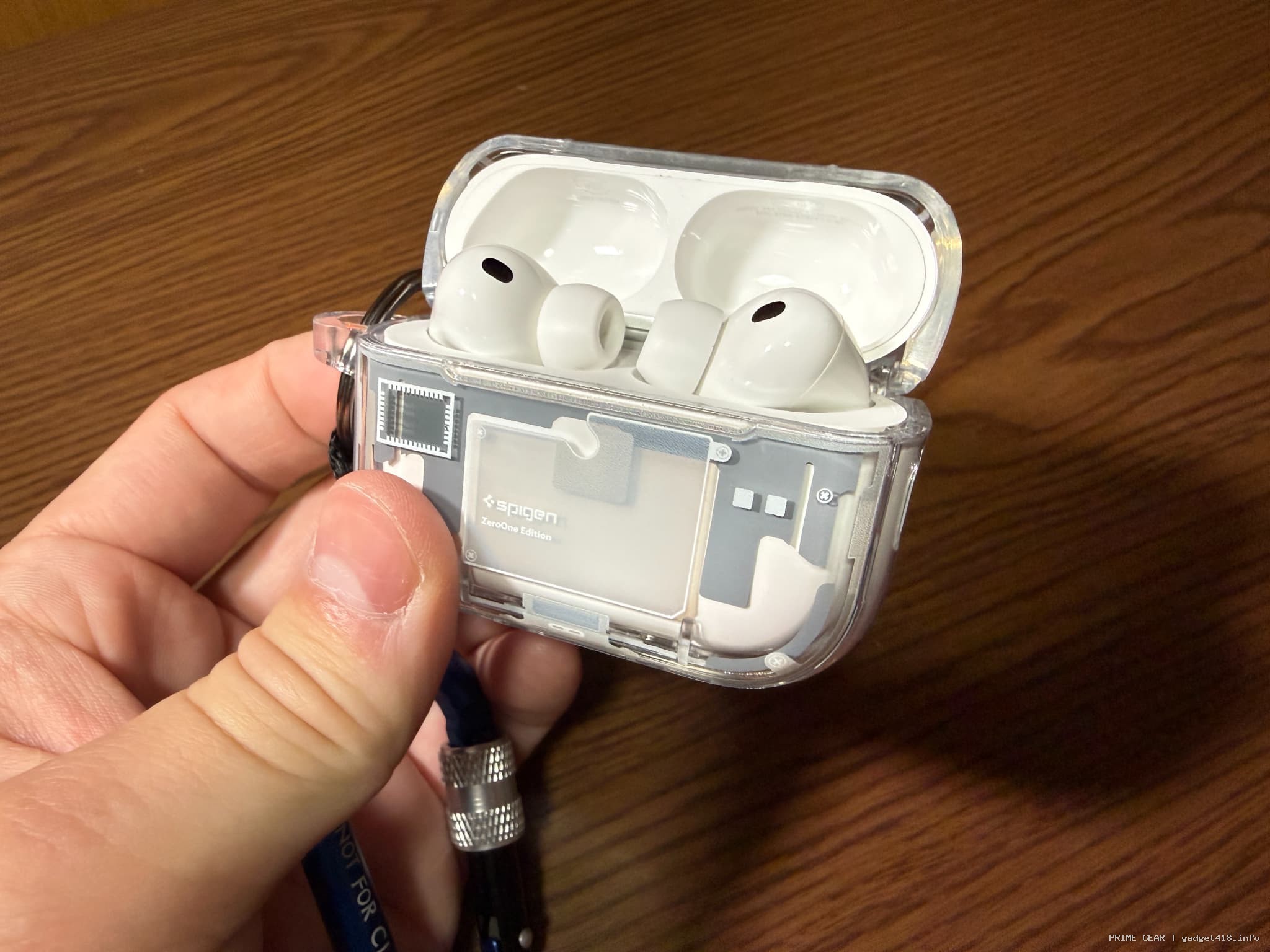 透明ケースに入った白いワイヤレスイヤホンを持つ手