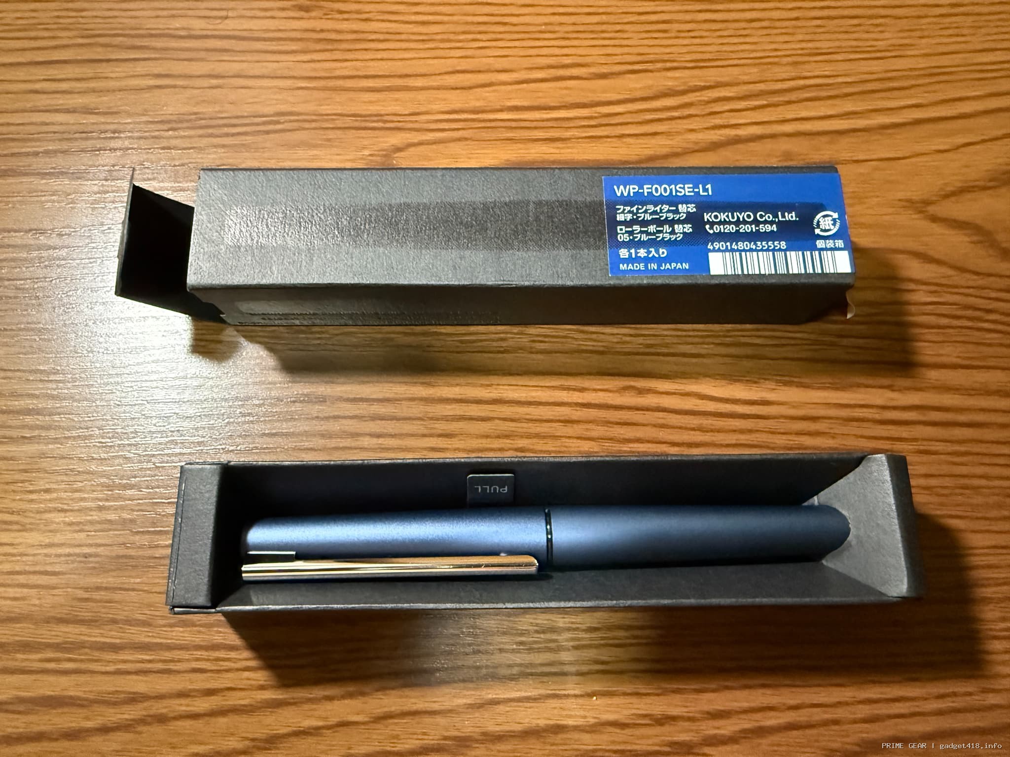 木目テーブルに置かれたコクヨの青いペンとブルーブラック替芯の箱