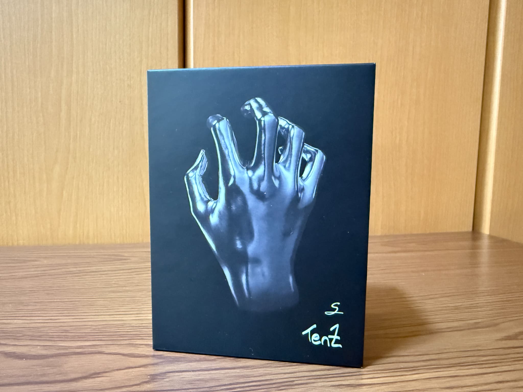 黒い箱に銀色の手のイラストとS Tentの文字