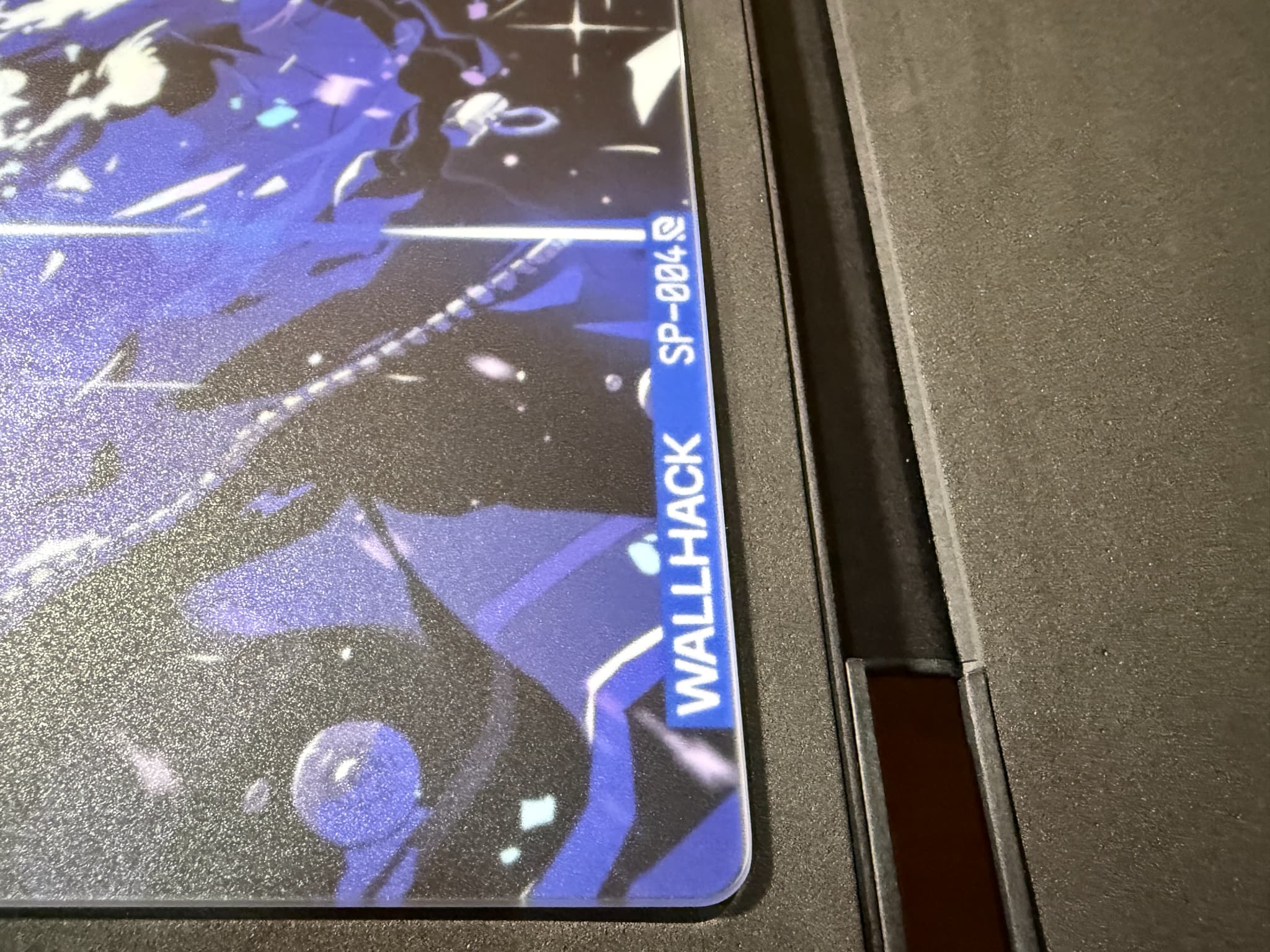 WALLHACK SP-004と書かれた青いマークのあるイラスト入りデスクマット