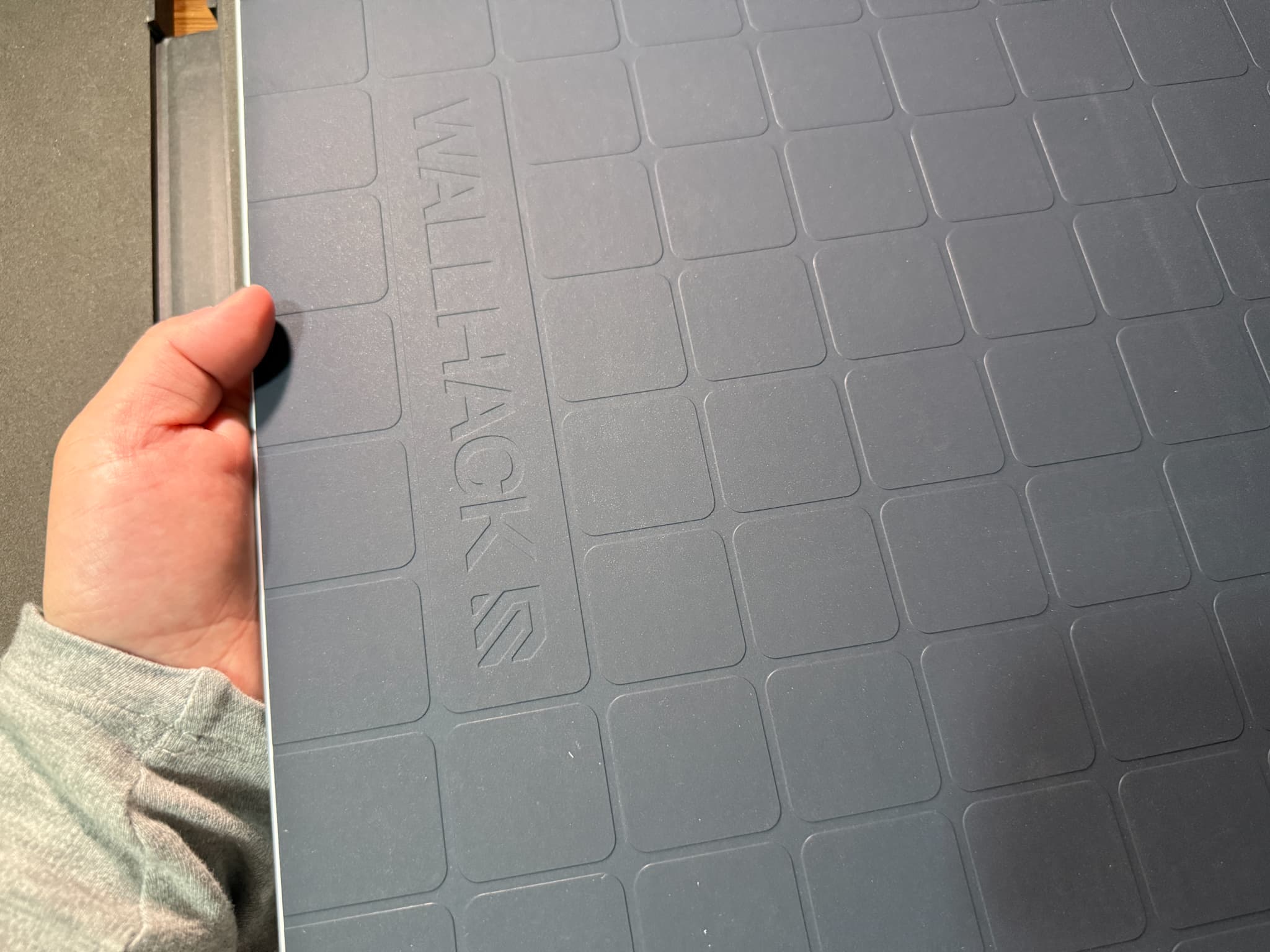 人が持つ壁掛け用タイルカーペット