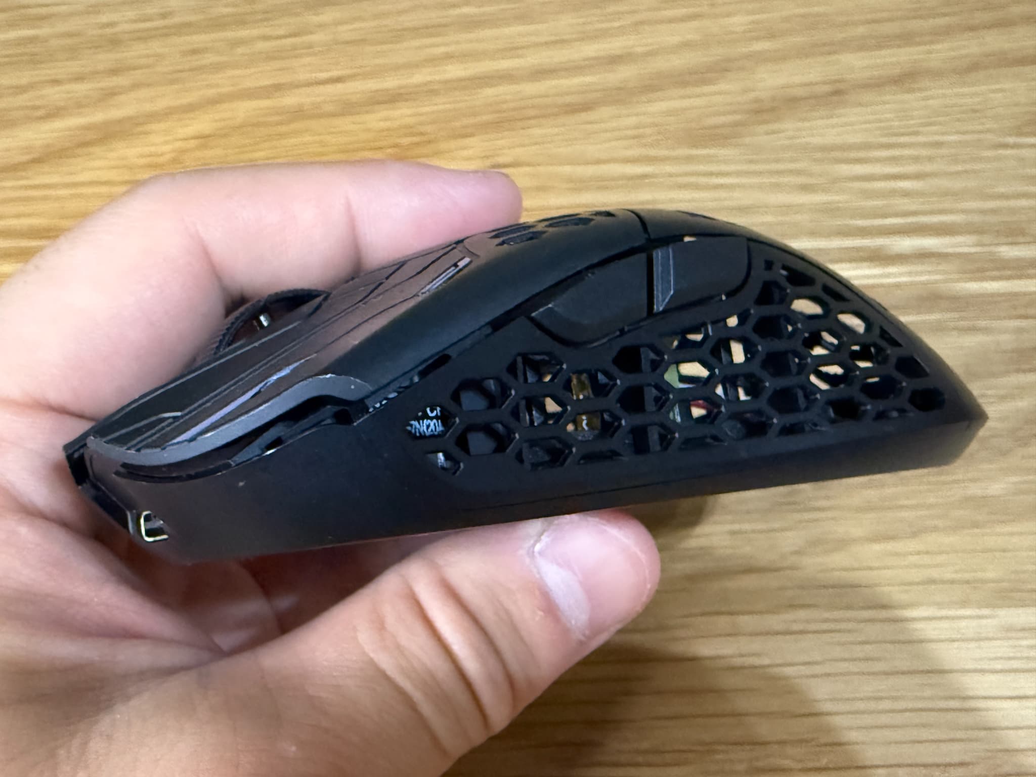 手のひらに乗ったハニカム構造の黒いマウス