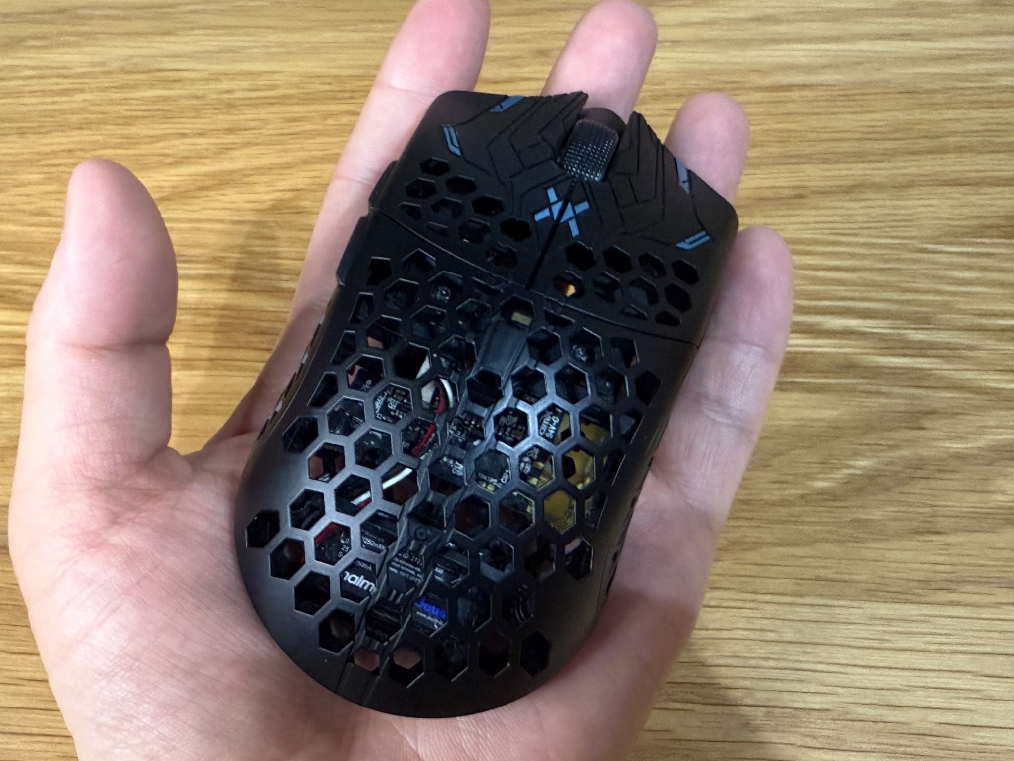 手のひらに乗ったハニカム構造の黒いパソコンマウス