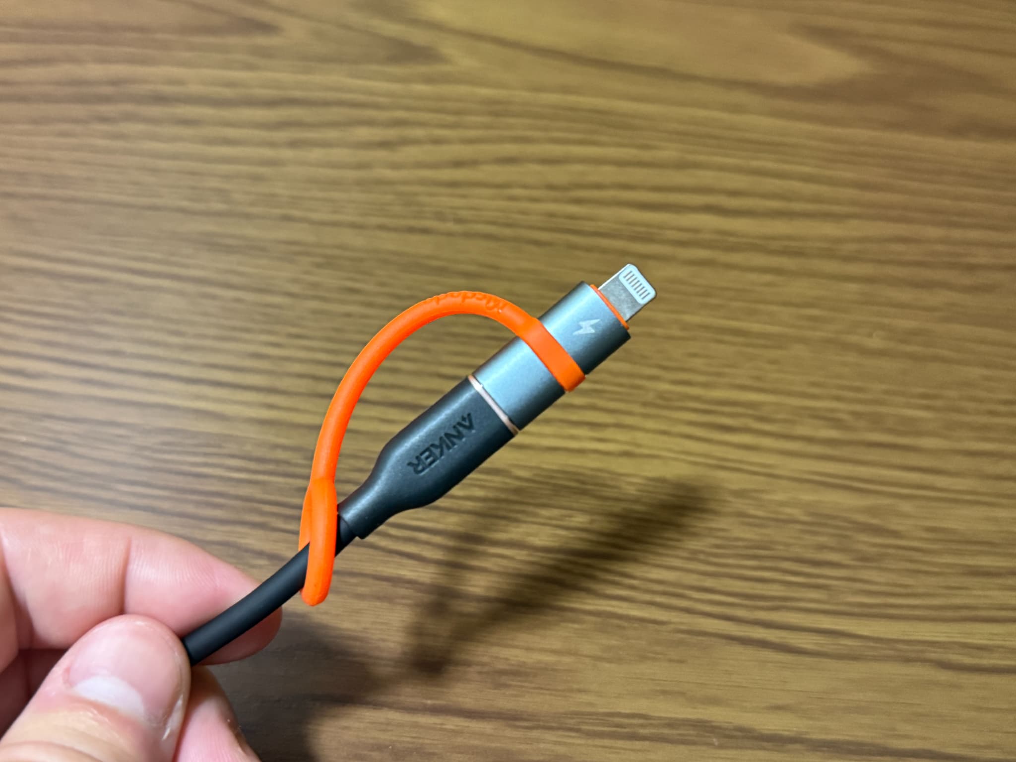 オレンジ色の留め具で束ねられたANKERのライトニングケーブル
