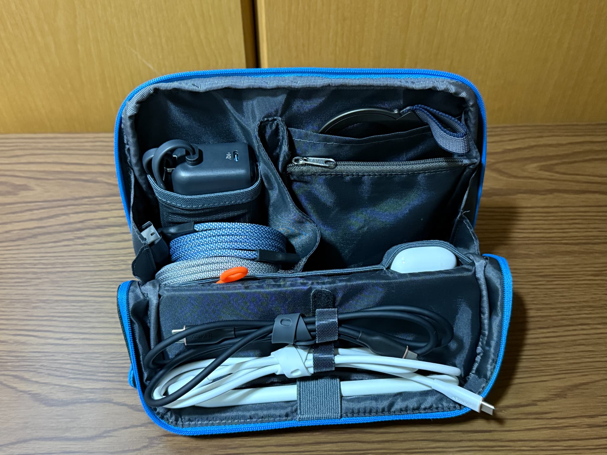 青い縁取りのモバイルバッテリーやケーブルなどを収納できるポーチ