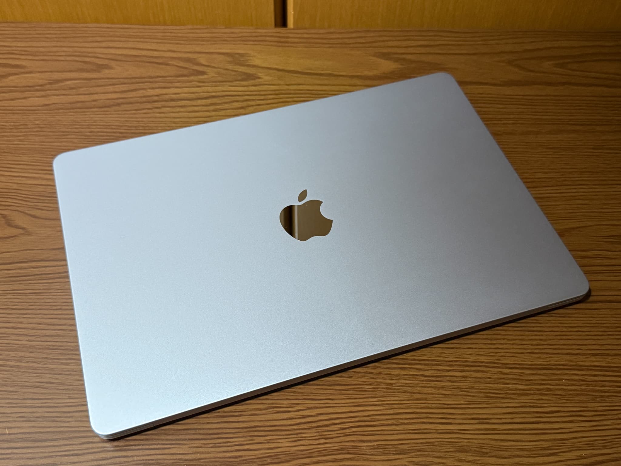 木のテーブルに置かれたアップルのノートパソコン